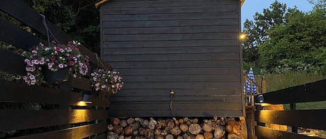 A rustic cabin with a wooden exterior, a fireplace, and a stone wall.