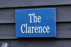 Un letrero azul con letras blancas que dice 'The Clarence'.