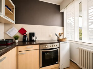 A modern kitchen with a built-in oven, a coffee maker, and a window with a view.