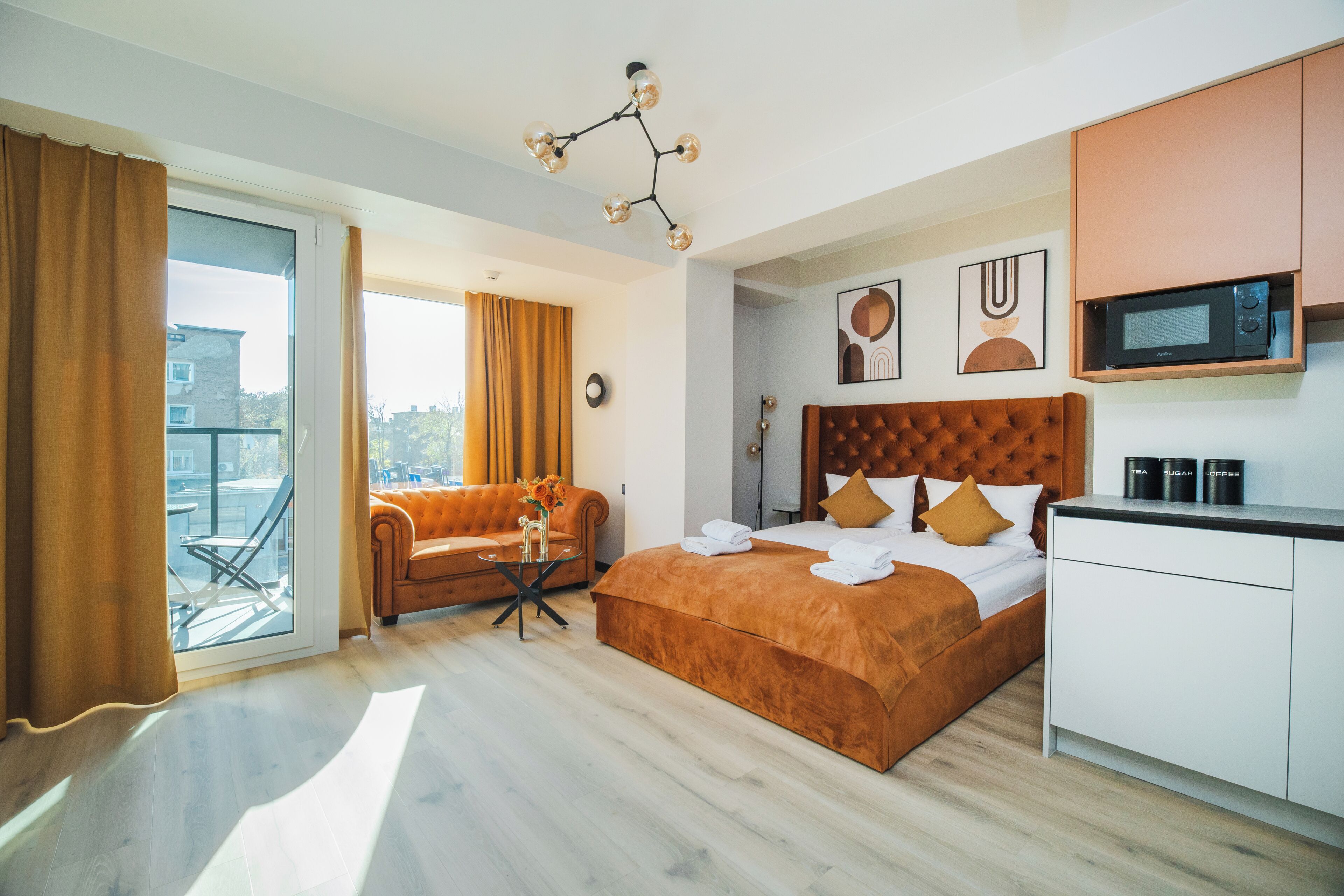 Habitación de hotel con cama, sofá, zona de comedor y vistas al exterior.