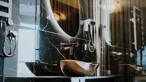 A bathroom with a large mirror, a sink, and a hairdryer.