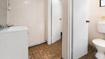 A bathroom with a white sink, mirror, and tiled walls.