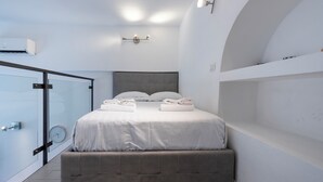 Une chambre à coucher moderne avec un lit, des lampes de chevet, une horloge et un banc intégré.