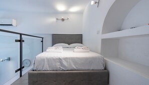 A modern bedroom with a bed, bedside lamps, a clock, and a built-in bench. - Italianway Easy - Verro 46 (Milan)