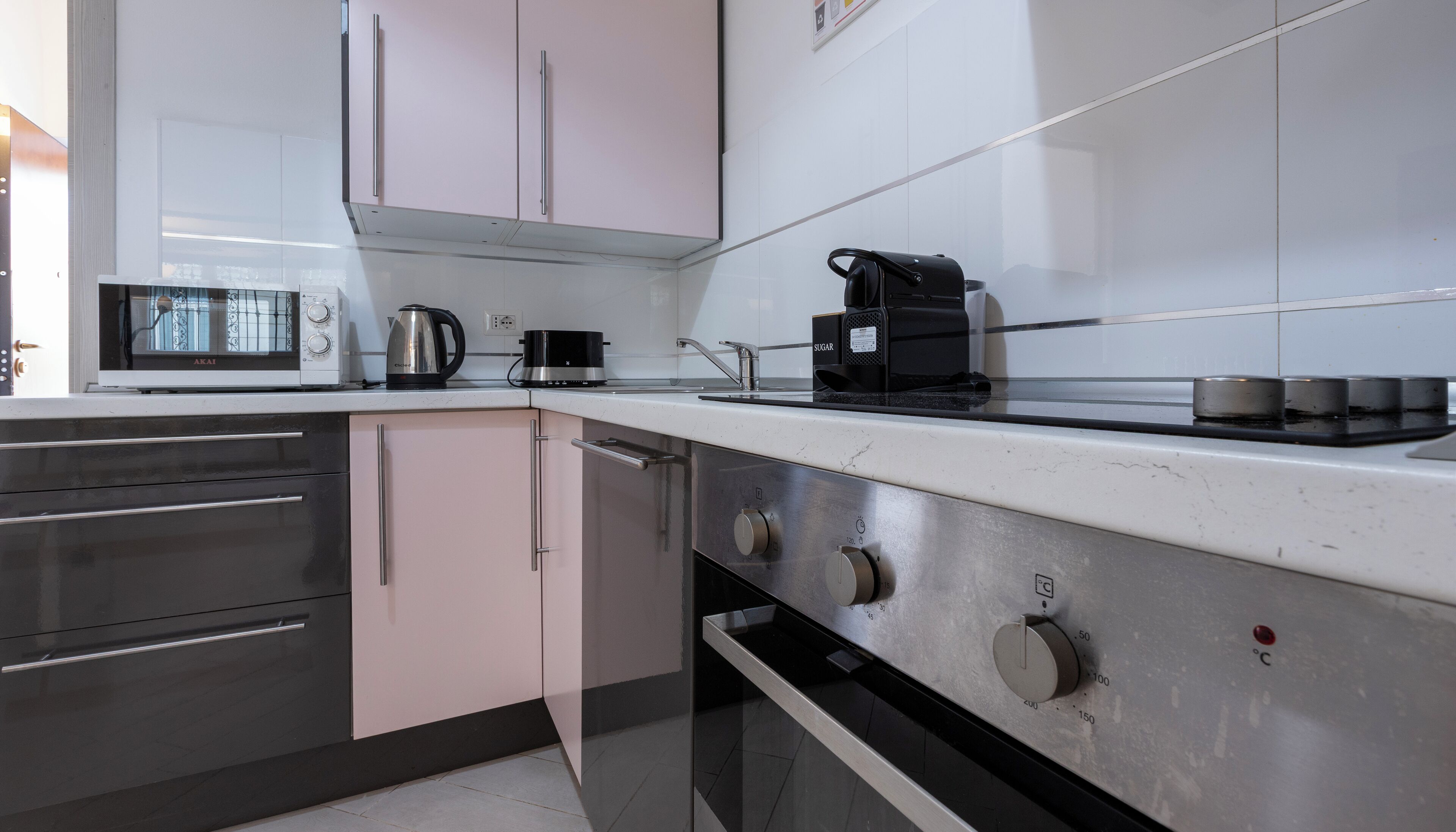 A modern kitchen with stainless steel appliances, a microwave, a kettle, and a coffee maker.