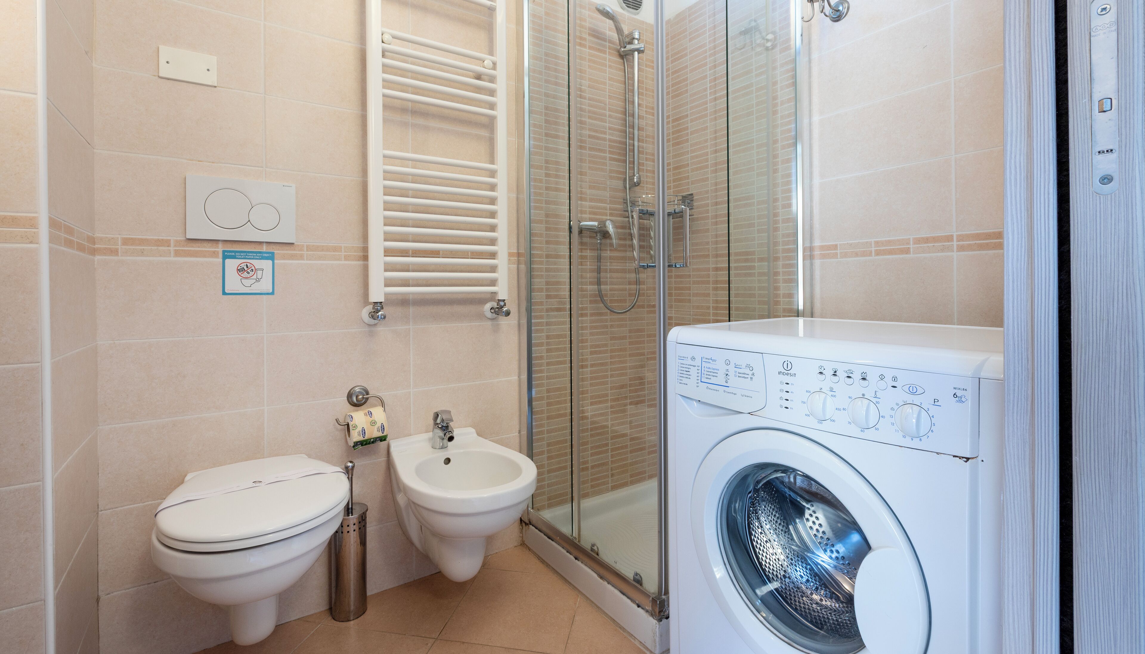 Un baño con inodoro, bidé y lavadora.