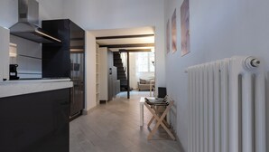 A modern kitchen with a built-in stove, a coffee maker, and a dining area with a table and chairs.