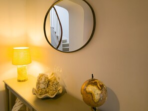 En lampe, et spejl og en globus på et bord.