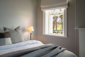 A bedroom with a bed, pillows, a lamp, and a window with a view of an outdoor area. - 'Glenworth House' - Heritage Berry Mountain Estate (Berry Mountain)