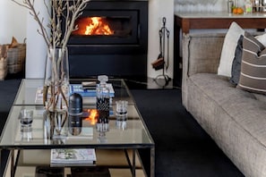 A living room with a glass coffee table, a fireplace, a sofa, and a vase with branches. - 'Glenworth House' - Heritage Berry Mountain Estate (Berry Mountain)