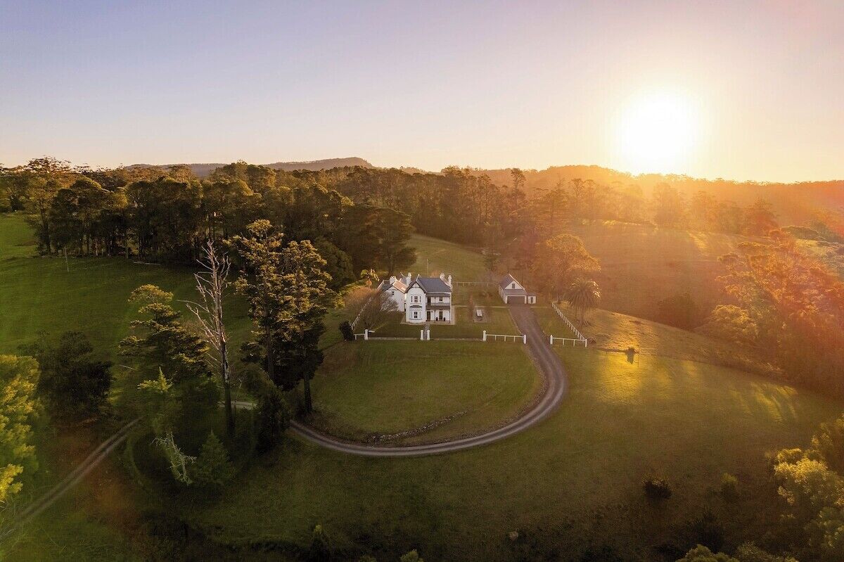 Una grande casa con vialetto e giardino recintato.
