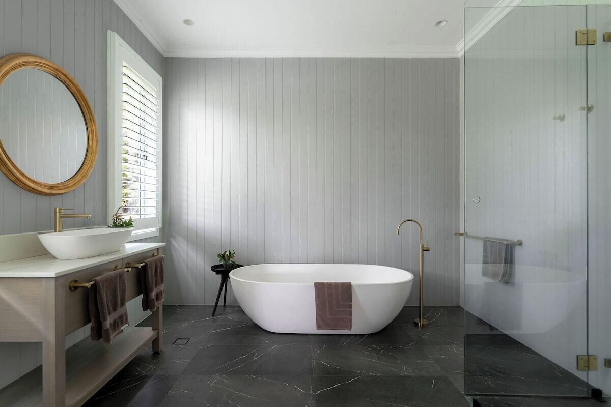 A modern bathroom with a freestanding bathtub, a vanity with a sink, and a glass shower enclosure.