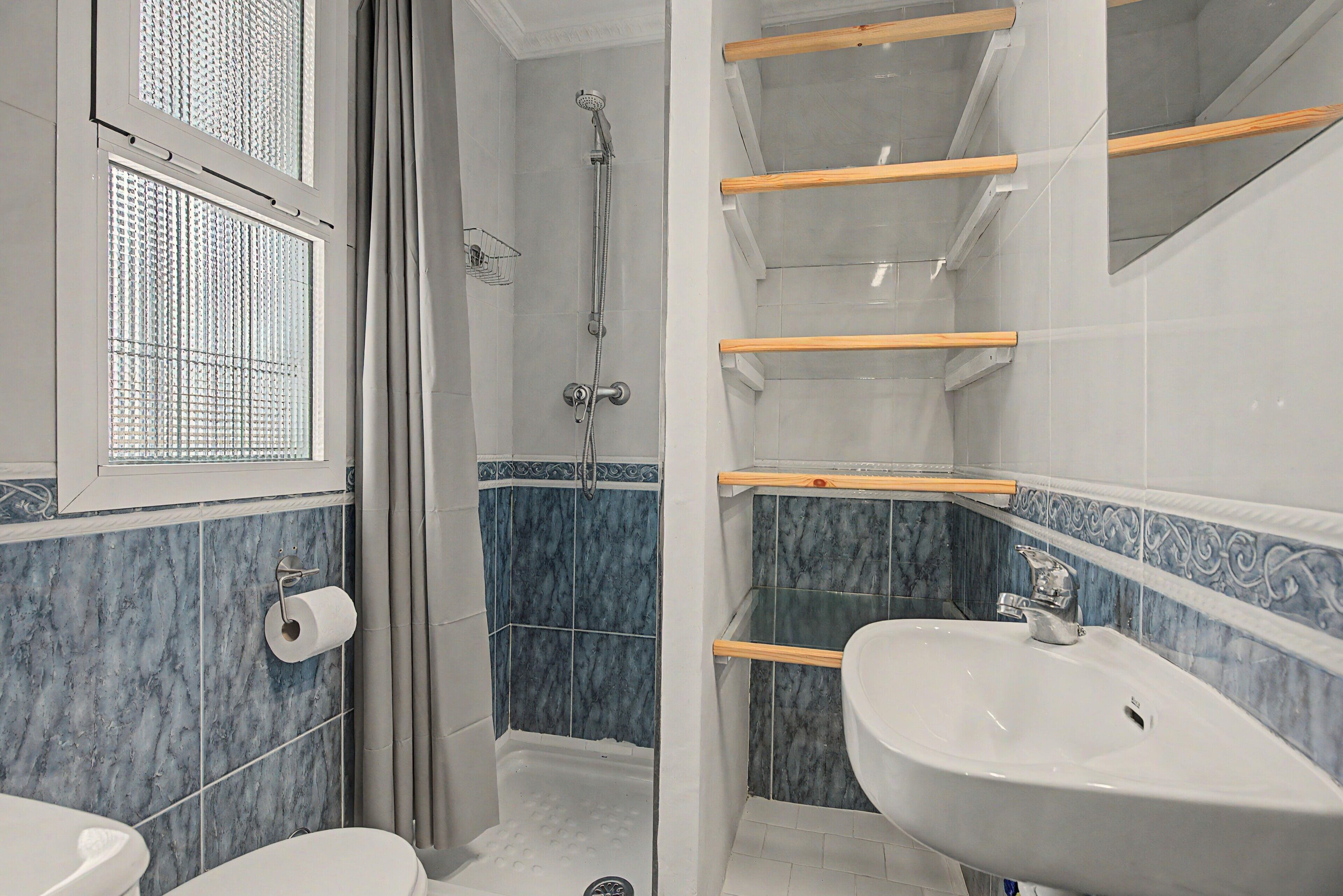 A bathroom with a shower, toilet, and sink.