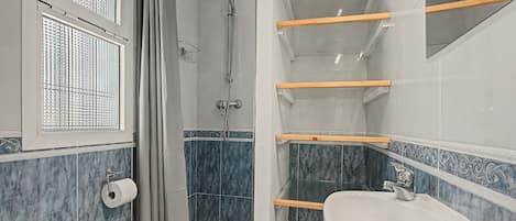 Ein Badezimmer mit Dusche, Toilette und Waschbecken.
