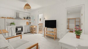 Eine moderne Küche mit weißen Schränken, einem eingebauten Backofen und einer Mikrowelle.