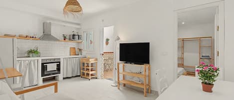A modern kitchen with white cabinetry, a built-in oven, and a microwave.