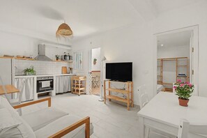 A modern kitchen with white cabinetry, a built-in oven, and a microwave. - ‘El Olivo 1’ Apartment with Private Terrace, Wi-Fi, and Air Conditioning (Málaga)