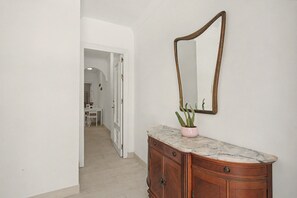 A hallway with a wooden cabinet, a marble countertop, and a potted cactus. - ‘El Olivo 1’ Apartment with Private Terrace, Wi-Fi, and Air Conditioning (Málaga)