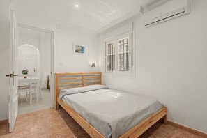 A bedroom with a wooden bed, a desk, and a chair. - ‘El Olivo 1’ Apartment with Private Terrace, Wi-Fi, and Air Conditioning (Málaga)