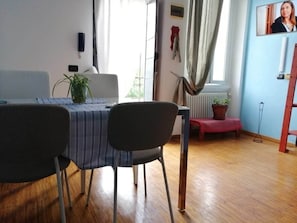 Ein Essbereich mit Tisch, Stühlen und einer Zimmerpflanze.