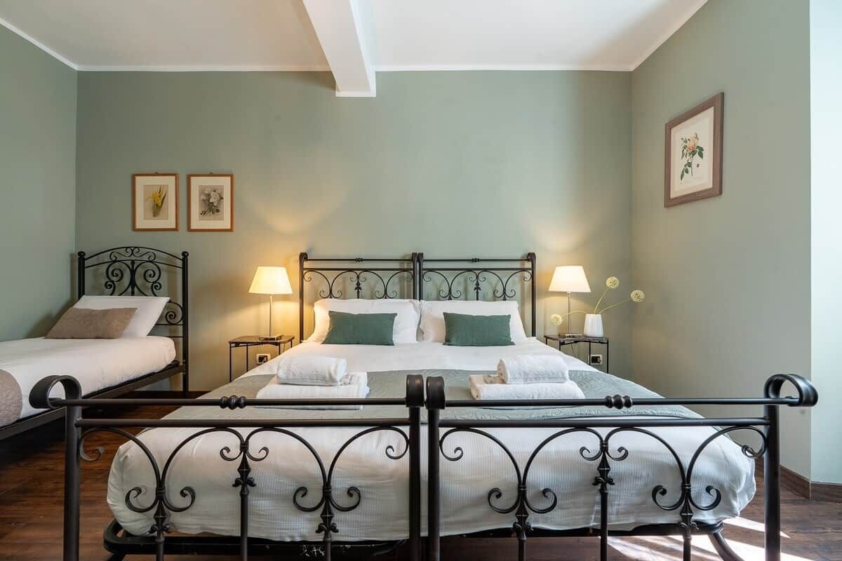 Una habitación de hotel con una cama grande, dos mesitas de noche y un cabecero.