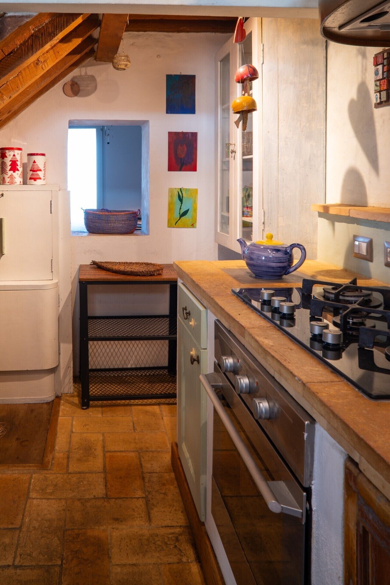 A kitchen with a gas stove, oven, and a window with a view.