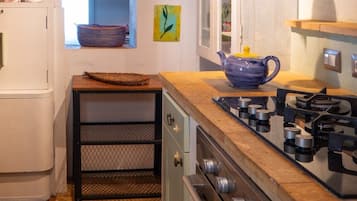 A kitchen with a gas stove, oven, and a window with a view.