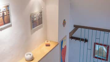 Una escalera con barandilla de madera y reja metálica.