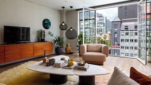 Uma sala de estar moderna com uma televisão grande, um armário de madeira e um sofá.