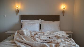 A bed with a headboard, two bedside lamps, and a blanket.