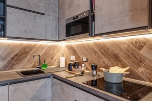 A modern kitchen with a built-in oven, a sink, and a stove. - Luxury Chianti Road - 3BR Free Parking (San Casciano in Val di Pesa)