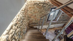 A wooden staircase with a stone wall on one side and a metal railing on the other. - Luxury Chianti Road - 3BR Free Parking (San Casciano in Val di Pesa)