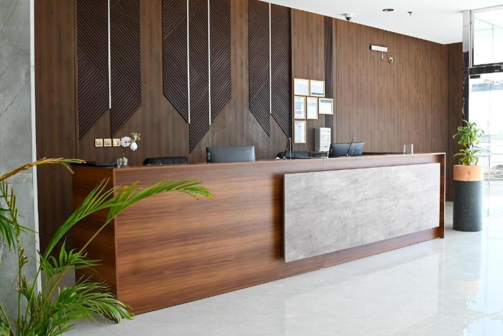 A reception desk with a wooden finish, a grey accent panel, and a modern design.