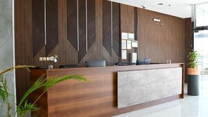 A reception desk with a wooden finish, a grey accent panel, and a modern design.