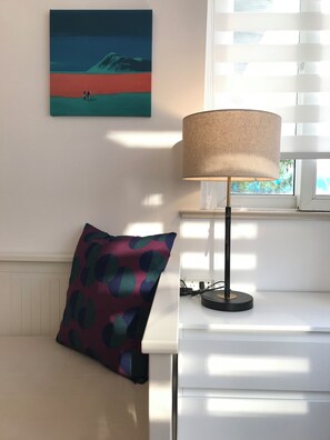 A room with a white desk, a lamp, a colorful pillow, and a painting on the wall. - Innocondo Extended Stay Changning  West Yan'an Road (Shanghai)