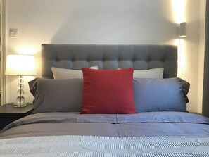 A bed with a grey headboard, white and red pillows, and a grey bedspread. - Innocondo Extended Stay West Yan'an Road (Shanghai)
