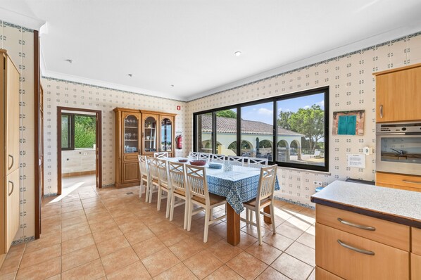 Una cocina amplia con zona de comedor, ventanas grandes y vistas al exterior.