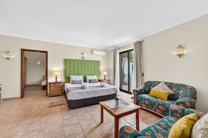 Une chambre d’hôtel avec un lit, un canapé, une petite table et une vue sur l’extérieur.