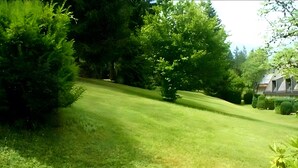 A well-maintained lawn with a gentle slope leading to a house. - Holiday at 1,000 Meters with Mountain View, Pool, Sauna, and Wi-Fi (Schönwald im Schwarzwald)