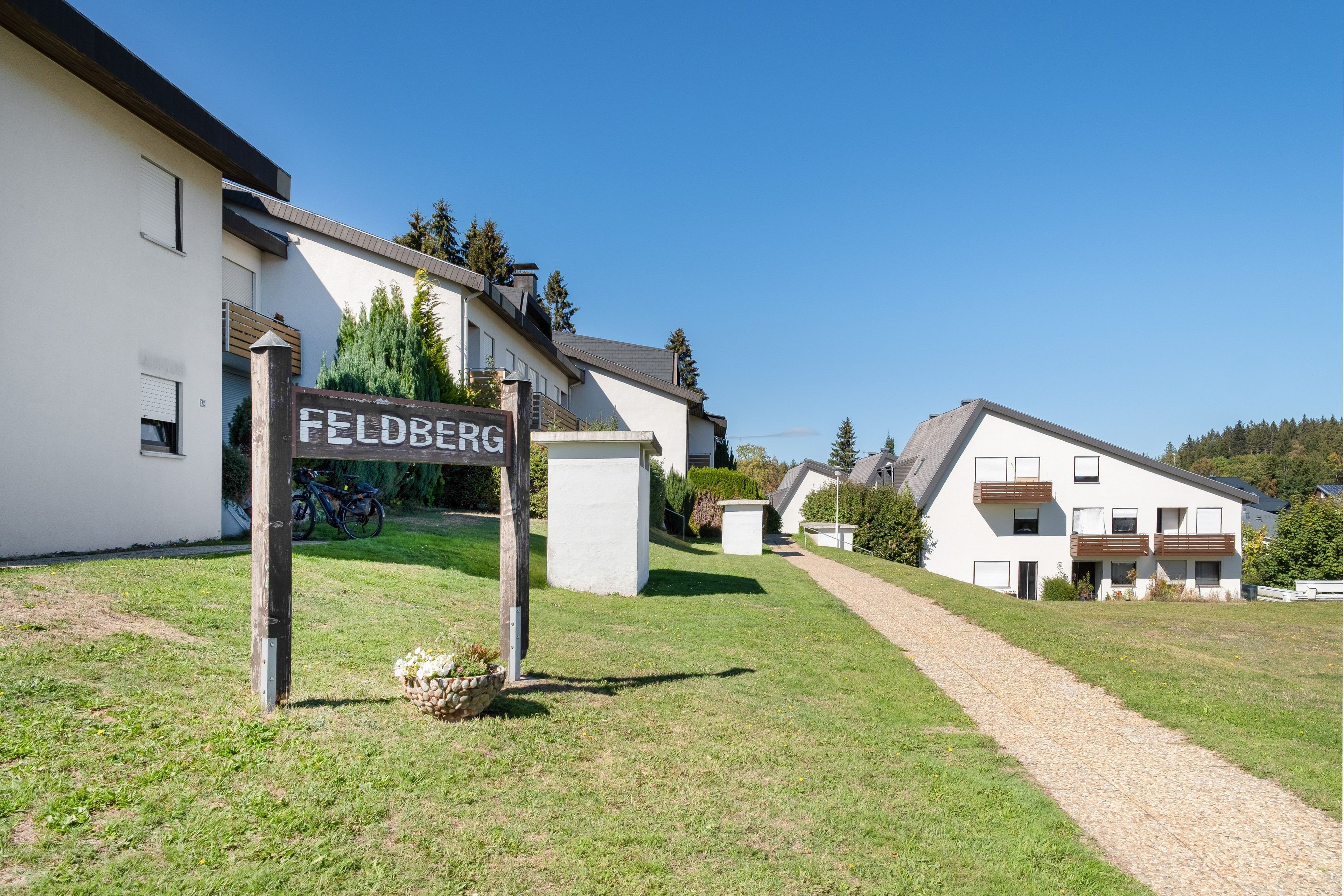 A residential area with a sign reading 'FELDBERG' and modern houses with balconies.
