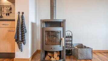 Eine moderne Küche mit Kaminofen, Holzschränken und einem hängenden Handtuchhalter.