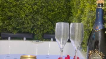 A table set with two wine glasses, a bottle of champagne, and a candle.