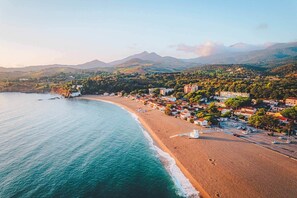 A coastal town with a beach, buildings, and mountains in the background. - L'Estiu Bleu - 1BR Near Beach (Argelès-sur-Mer)