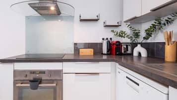 A modern kitchen with stainless steel appliances, a glass cooktop, and a built-in oven.