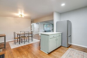 Eine moderne Küche mit Essbereich, Holzboden und einem Kühlschrank.