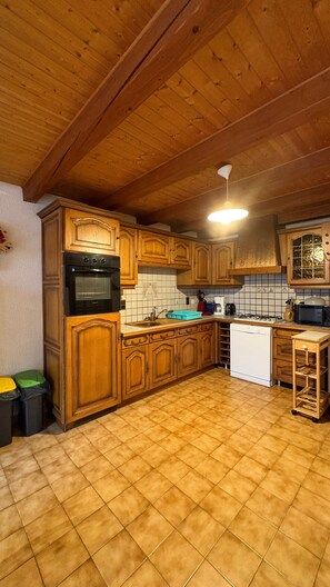 A kitchen with wooden cabinets, a stove, and a tiled backsplash. - Apartment 'Logement Entier 8 Couchages Wifi' with Mountain View and Wi-Fi (Saint François Longchamp)