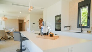 A modern kitchen with a central island, bar stools, and pendant lighting. - CostaBlancaDreams - Villa Ortenbach in Calpe (Calpe / Calp)
