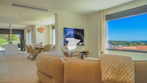 A modern living room with a large window, a sofa, a dining area, and a kitchen. - CostaBlancaDreams - Villa Ortenbach in Calpe (Calpe / Calp)