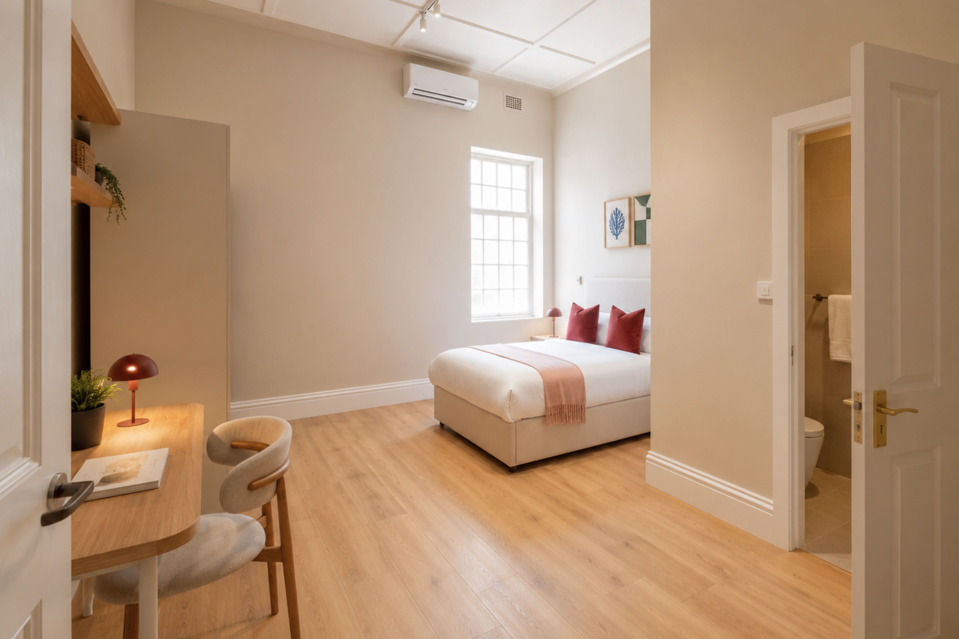 A bedroom with a bed, a desk, and a chair.