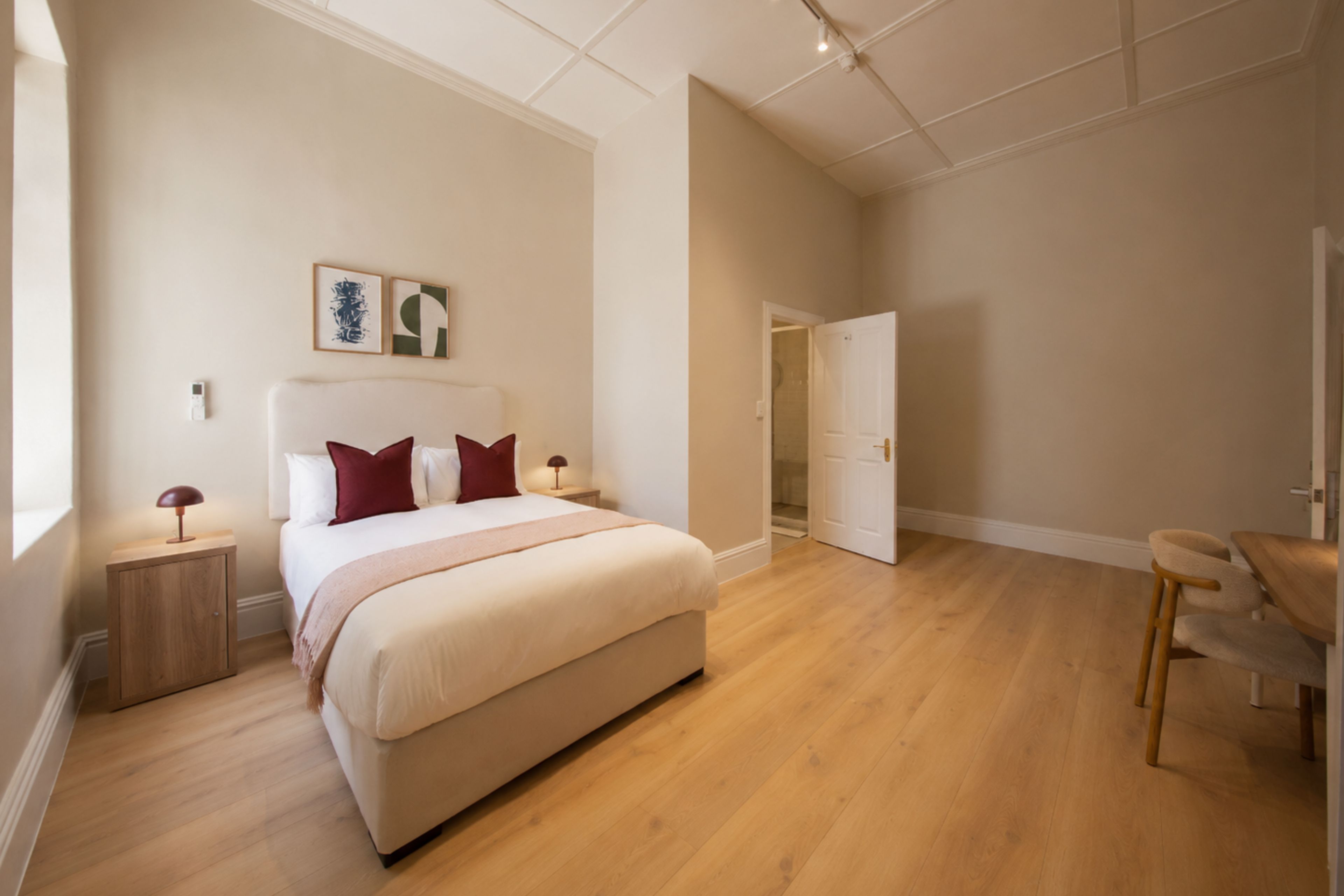 Une chambre spacieuse avec un grand lit, des tables de chevet et un fauteuil.